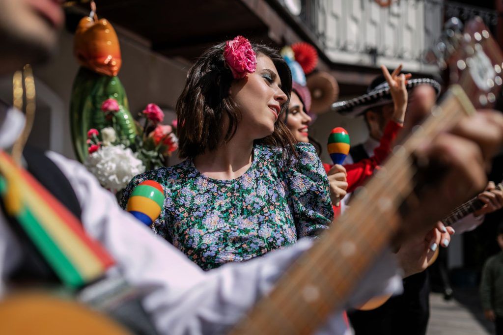A lively celebration with musicians and dancers in traditional Mexican attire.