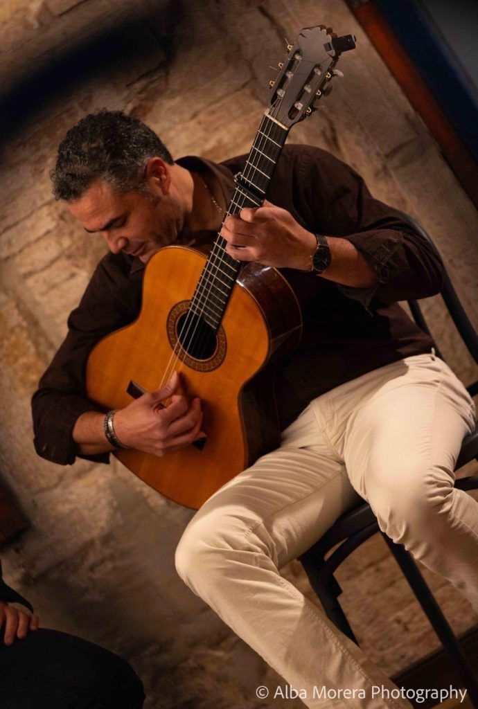 Guitarrista flamenco tocando sentado